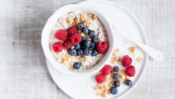 Eine Schüssel mit Quark-Porridge und Beeren steht auf einem Tisch. © NDR Foto: Claudia Timmann