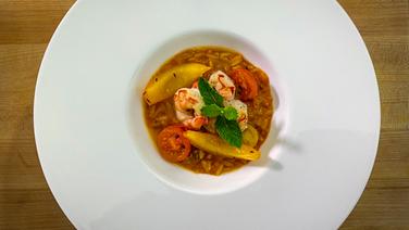 Ein Pastasotto aus Risoni mit Rotgarnelen ist auf einem weißen Teller angerichtet. © NDR 