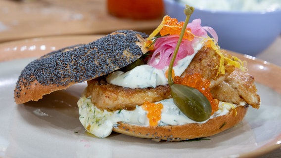 Mit Backfisch belegter Bagel auf einem Teller. © NDR Foto: Claudia Timmann