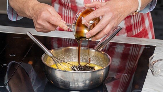 Eine Köchin verrührt Sirup und aufgeschlagene  Eier für Braune Kuchen © NDR Foto: Claudia Timmann