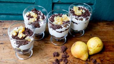 Cheesecake-Creme mit Kakao-Sternaniscrumble und Birne in Gläsern serviert. © NDR Foto: Claudia Timmann