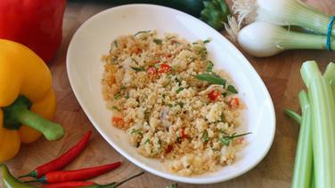 Couscous-Salat in einer Schale. Daneben liegen rote und gelbe Paprika, Lauch und Chili. © NDR Foto: Florian Kruck