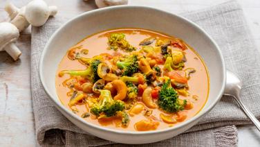 A deep dish with a vegetable broth and cashew nuts.  © NDR Photo: Claudia Timmann