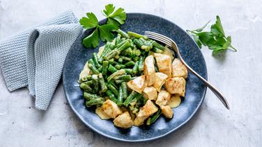 A plate of chicken and beans in a curry sauce.  © NDR Photo: Claudia Timmann