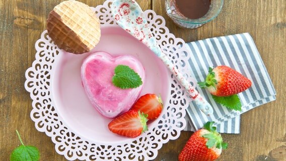Erdbeereis in Herzenform auf einem Teller mit keks und Erbeeren. © Fotolia Foto: Scerpica