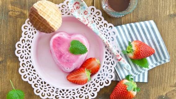 Erdbeereis in Herzenform auf einem Teller mit keks und Erbeeren. © Fotolia Foto: Scerpica