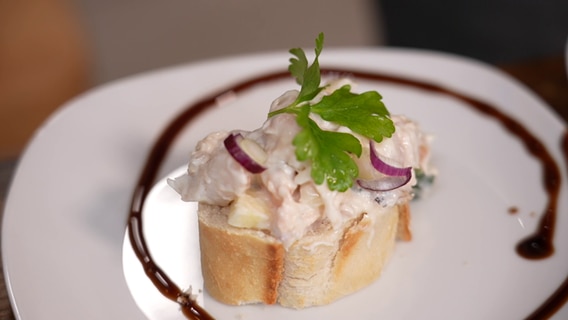 Räucherfischsalat ist auf einem Brot angerichtet. © NDR 