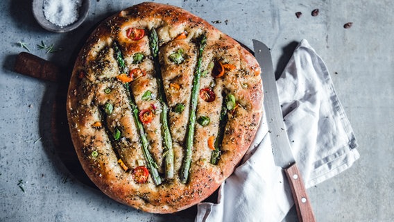 Eine Focaccia mit Spargel liegt auf einer Arbeitsfläche © NDR Foto: Dörte Haupt