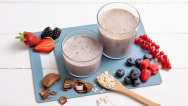 Zwei Gläser mit einem Frühstücksshake, daneben frische Beeren und Paranüsse. © NDR Foto: Claudia Timmann