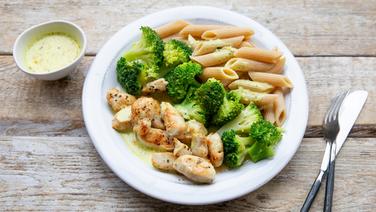 A dish with chicken meat, pasta and broccoli lies on a plate.  © NDR Photo: Claudia Timmann