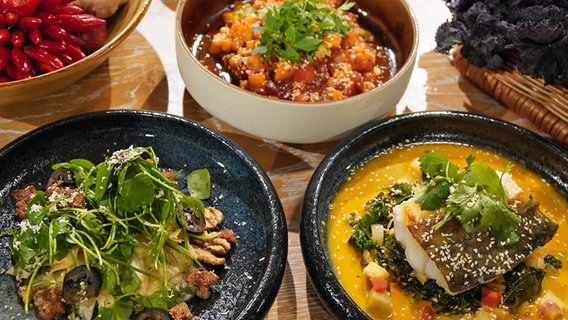Sellerie-Salat mit Walnüssen, orientalischer Steckrüben-Eintopf und Grünkohl-Curry mit Kabeljau auf drei Tellern © NDR Foto: Florian Kruck