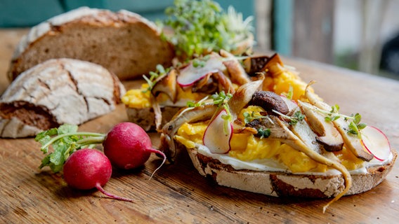 Käse-Rührei mit Pilzen auf Brot serviert © NDR Foto: Claudia Timmann