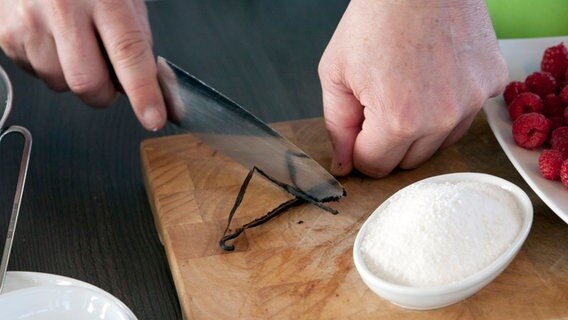 Zwei Hände schaben mit einem Messer eine Vanilleschote aus © NDR Foto: Claudia Timmann