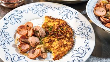 Kartoffelpfannkuchen mit Wurstsalat auf einem Teller serviert. © NDR Foto: Florian Kruck