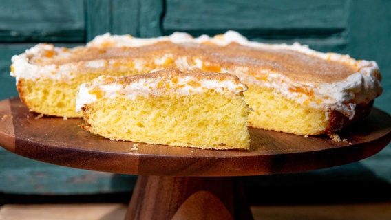 Orangenlimonaden-Kuchen auf einer hölzernen Tortenplatte. © NDR Foto: Claudia Timmann