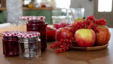 Beeren-Apfelmarmelade in Gläsern und frische Früchte auf einer Arbeitsplatte. © NDR Foto: Claudia Timmann
