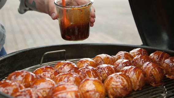 Große Fleischbällchen auf einem Grill. © NDR 