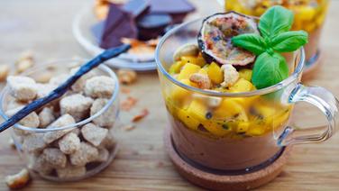 A glass mug with chocolate mousse, diced mango and half a passion fruit © NDR Photo: Florian Kruck