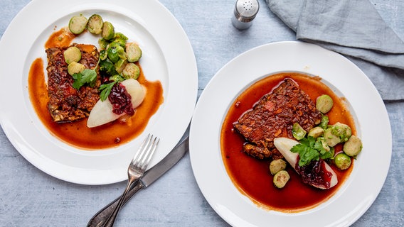 Zwei Teller mit Nussbraten, Soße und Rosenkohl. © NDR Foto: Claudia Timmann