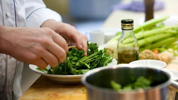 Lafer zupft frische Kräuter für eine Soße © NDR Foto: Claudia Timmann