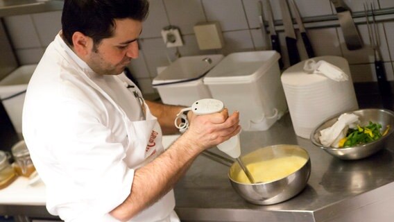 Ali Güngörmüs schäumt eine Paprika-Rhabarber-Suppe mit einem Pürierstab auf. © NDR Foto: Claudia Timmann
