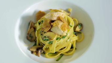 Tagliatelle with diced chicken, mushrooms and yeast on a white plate © NDR Photo: Dirk Luther
