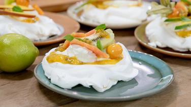 Pavlova mit Creme und exotischen Früchten auf einem Teller serviert. © NDR Foto: Claudia Timmann