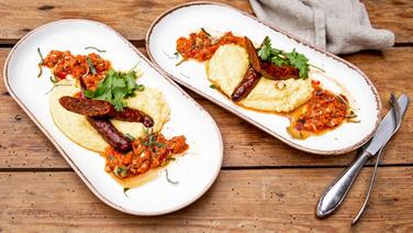Salbei-Polenta mit Paprika-Relish und Merguez auf einem Teller serviert. © NDR Foto: Claudia Timmann