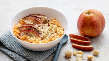 Eine Schale mit Hirseporridge und Obst, daneben ein Apfel. © NDR Foto: Claudia Timmann