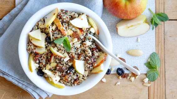 Eine Schale mit Quinoa, Trockenfrüchten und Apfelspalten. © NDR Foto: Claudia Timmann