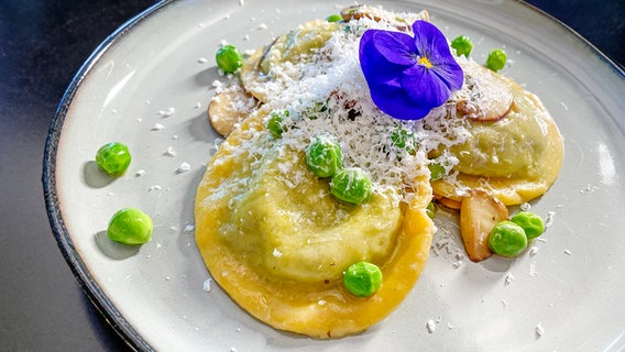 Erbsen-Bärlauch-Ravioli mit Champignons und Schafskäse auf einem Teller angerichtet © NDR 