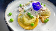 Erbsen-Bärlauch-Ravioli mit Champignons und Schafskäse auf einem Teller angerichtet © NDR 