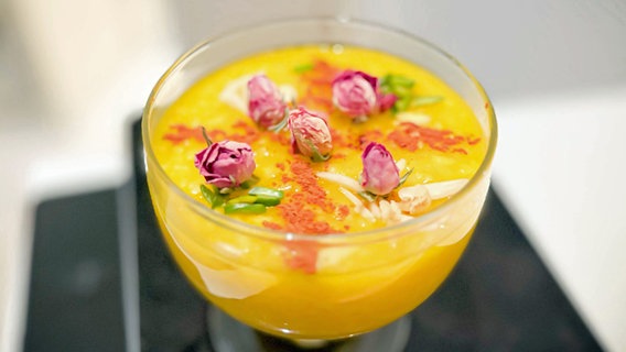 Persischer Reispudding mit Rosenblüten in einem Glas serviert © NDR Foto: Dave Hänsel