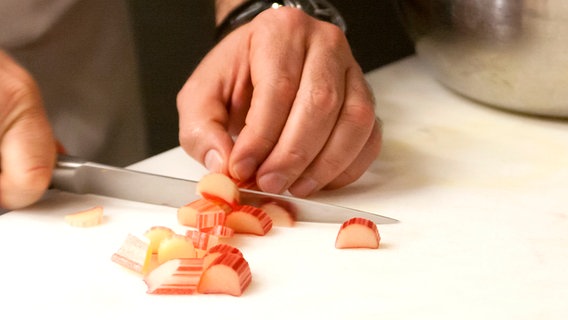 Rhabarber wird mit einem Messer in Stücke geschnitten. © NDR Foto: Claudia Timmann