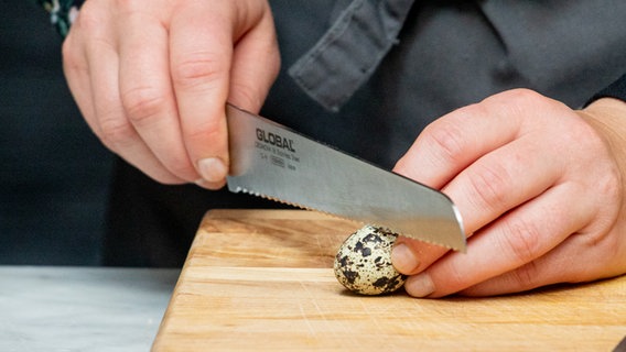 Ein Wachtelei wird mit einem Messer vorsichtig geöffnet © NDR Foto: Claudia Timmann