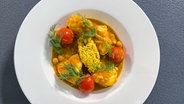 Rotbarsch-Filet in Curry-Kokosmilch auf einem Teller serviert © NDR 