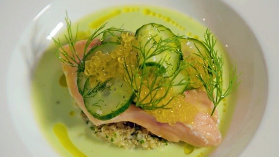 Saiblingsfilet mit Gurkenscheiben, Kaviar auf Quinoa auf einem weißen Teller © NDR 