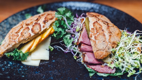 Zwei Sandwiches - eines mit Käse, eines mit Roastbeef belegt - liegen auf einem Teller. © NDR Foto: Björn Lindenblatt