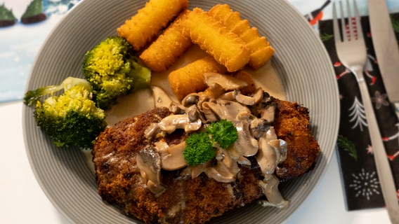 Ein Schnitzel mit Brokkoli und Kroketten auf einem Teller. © NDR Foto: Franziska Husmann