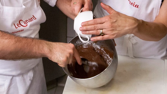 Das Zucker-Vanillegemisch wird zur Schokomasse gegeben. © NDR Foto: Claudia Timmann