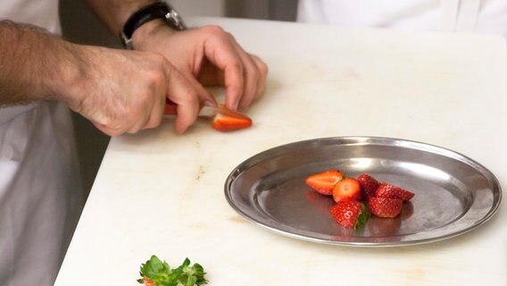 Ali Güngörmüs halbiert Erdbeeren. © NDR Foto: Claudia Timmann