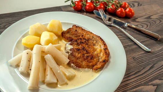 Schwarzwurzeln, Kartoffeln, ein Schnitzel und Sauce Bernaise sind auf einem Teller angerichtet. © NDR 