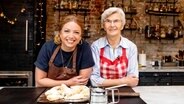 Zora Klipp und ihre Oma stehen in einer Küche vor einem Brett mit Christstollen-Scones. © NDR Foto: Claudia Timmann