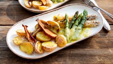 Weißer und Grüner Spargel mit Basilikum-Hollandaise, Ofenkartoffeln und Pilz-Chips auf einem Teller serviert. © NDR Foto: Claudia Timmann