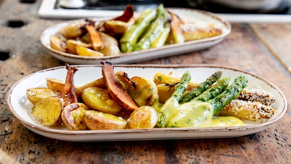 Weißer und Grüner Spargel mit Basilikum-Hollandaise, Ofenkartoffeln und Pilz-Chips auf einem Teller serviert. © NDR Foto: Claudia Timmann