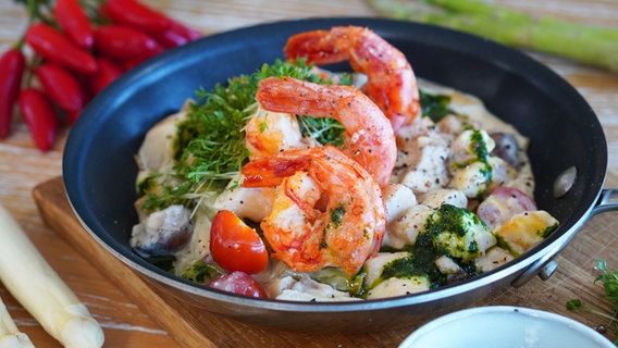 Pan with asparagus and vegetable fricassee topped with shrimp.  © NDR Photo: Florian Crook