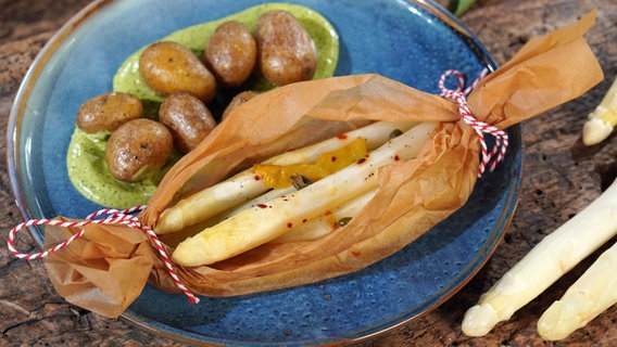 Spargel-Päckchen mit Bärlauch-Hollandaise und Drillingen auf einem Teller serviert © NDR Foto: Florian Kruck