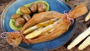 Spargel-Päckchen mit Bärlauch-Hollandaise und Drillingen auf einem Teller serviert © NDR Foto: Florian Kruck