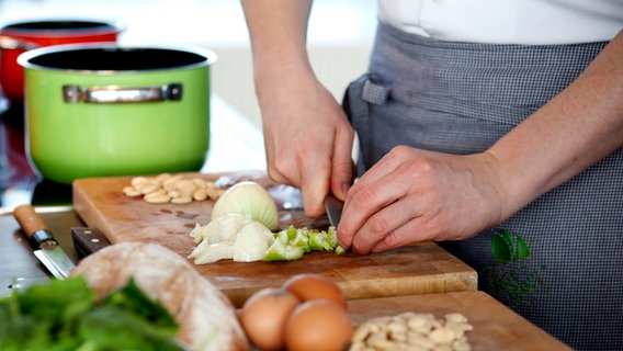 Matthias Gfrörer schneidet Zwiebeln und Sellerie für die Spinatsuppe. © NDR Foto: Claudia Timmann