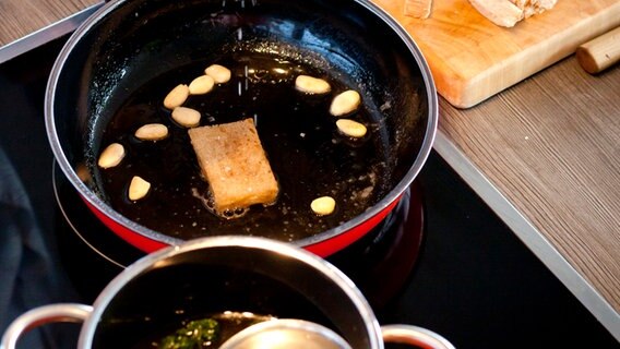 Eine Scheibe Brot und Mandeln werden in einer Pfanne geröstet. © NDR Foto: Claudia Timmann